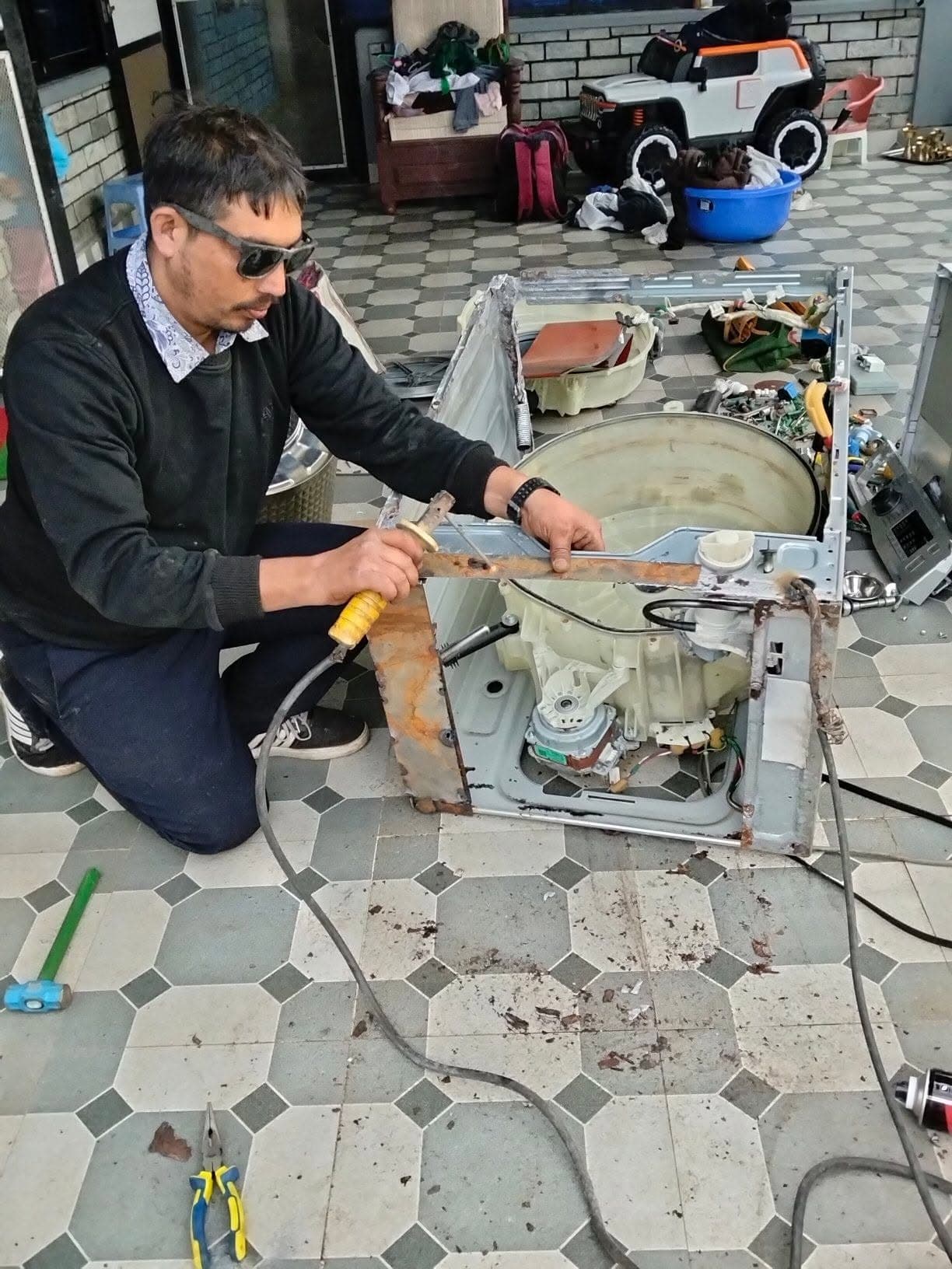 Technician repairing a washing machine at a customer's home